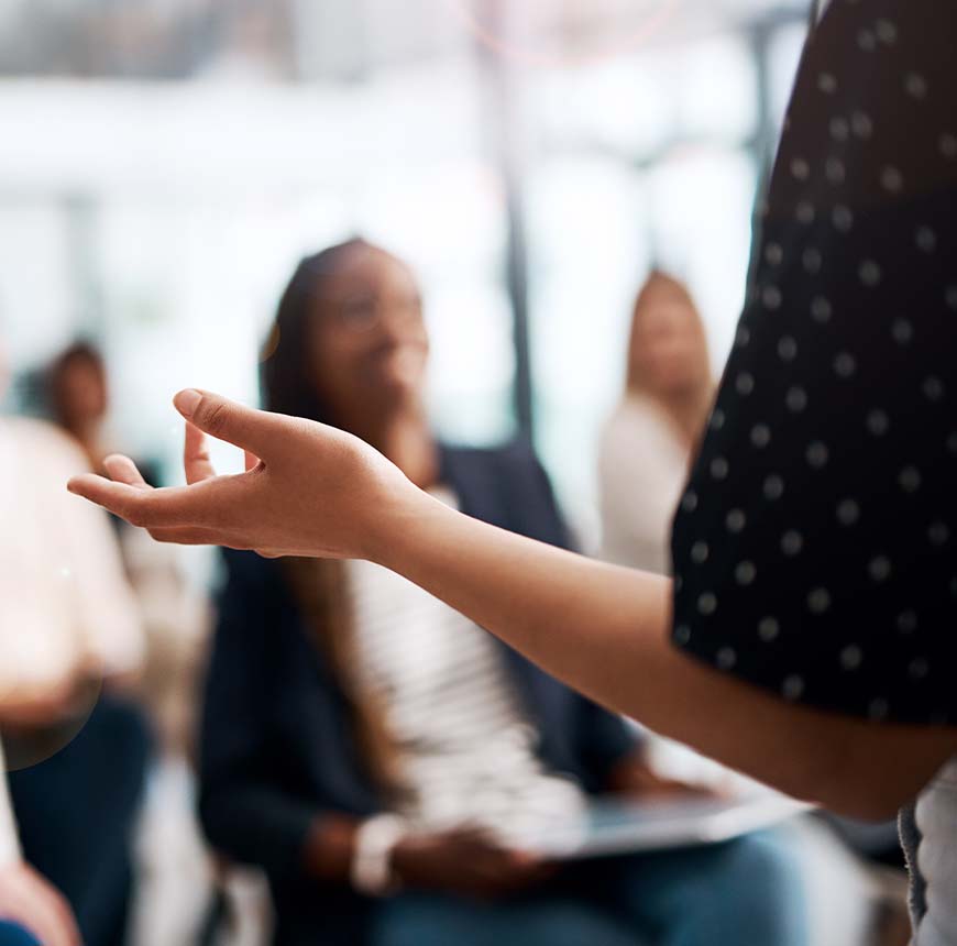 woman presenting to group at large meeting